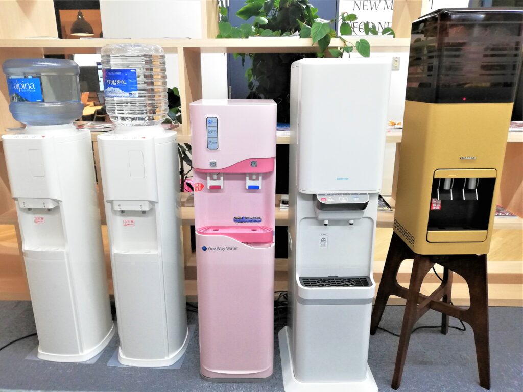 ウォーターサーバー五台を並べた様子。左からアルピナウォーター・信濃湧水・ワンウェイウォーター・サントリー天然水・プレミアムウォーター